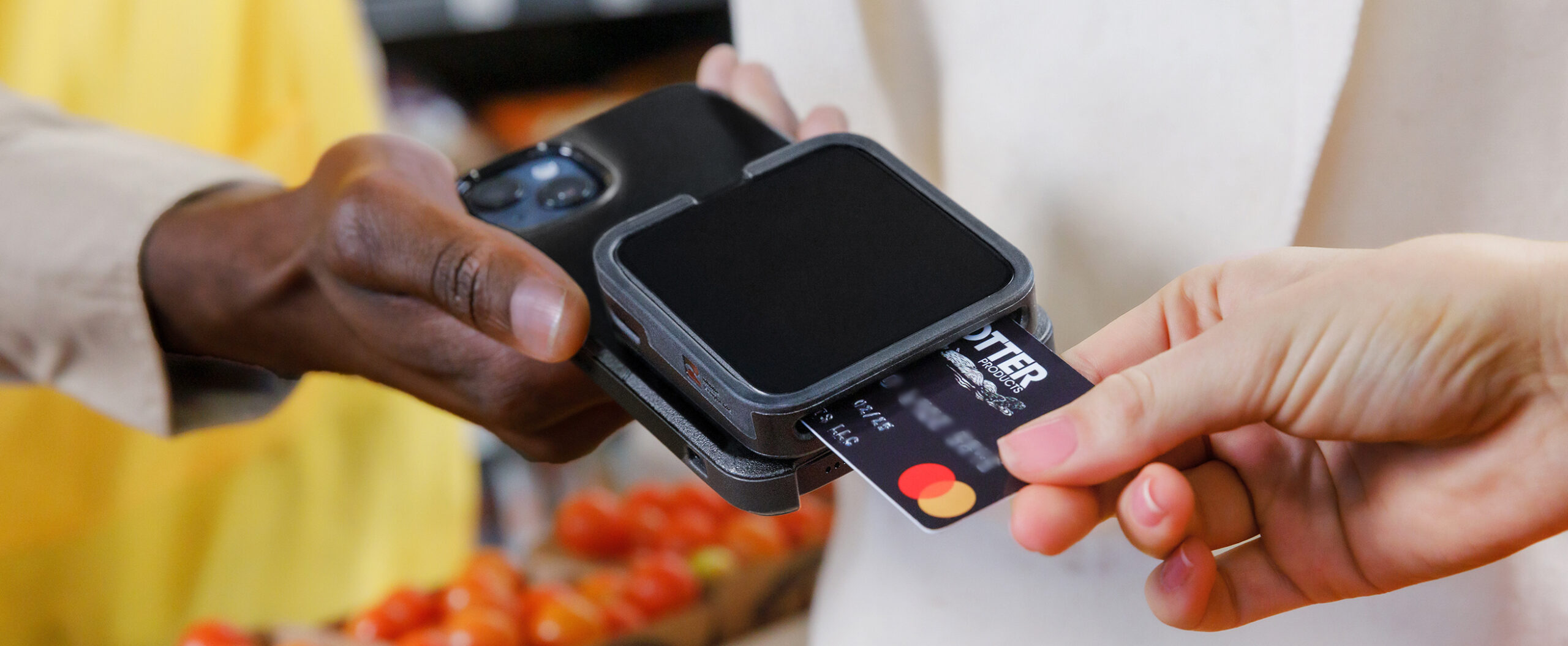 B2B_91912_Retail_Imagev2 A credit card being processed on a card reader connected to a phone