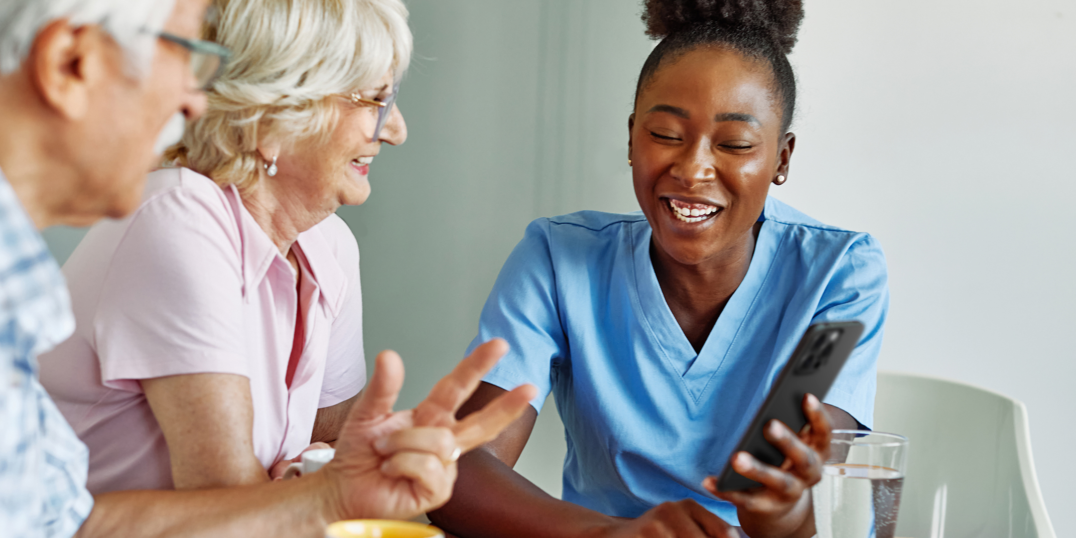 Acessories_Healthcare A healthcare professional reviewing information of a phone with two individuals